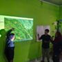 Community members study a projected forest map during an FPIC consultation in Enrekang