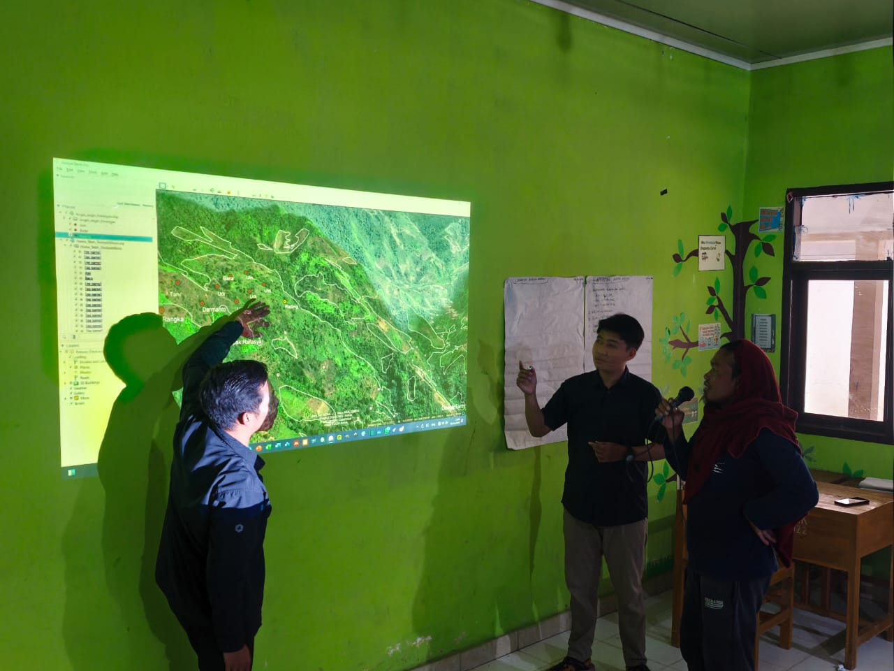 Community members study a projected forest map during an FPIC consultation in Enrekang